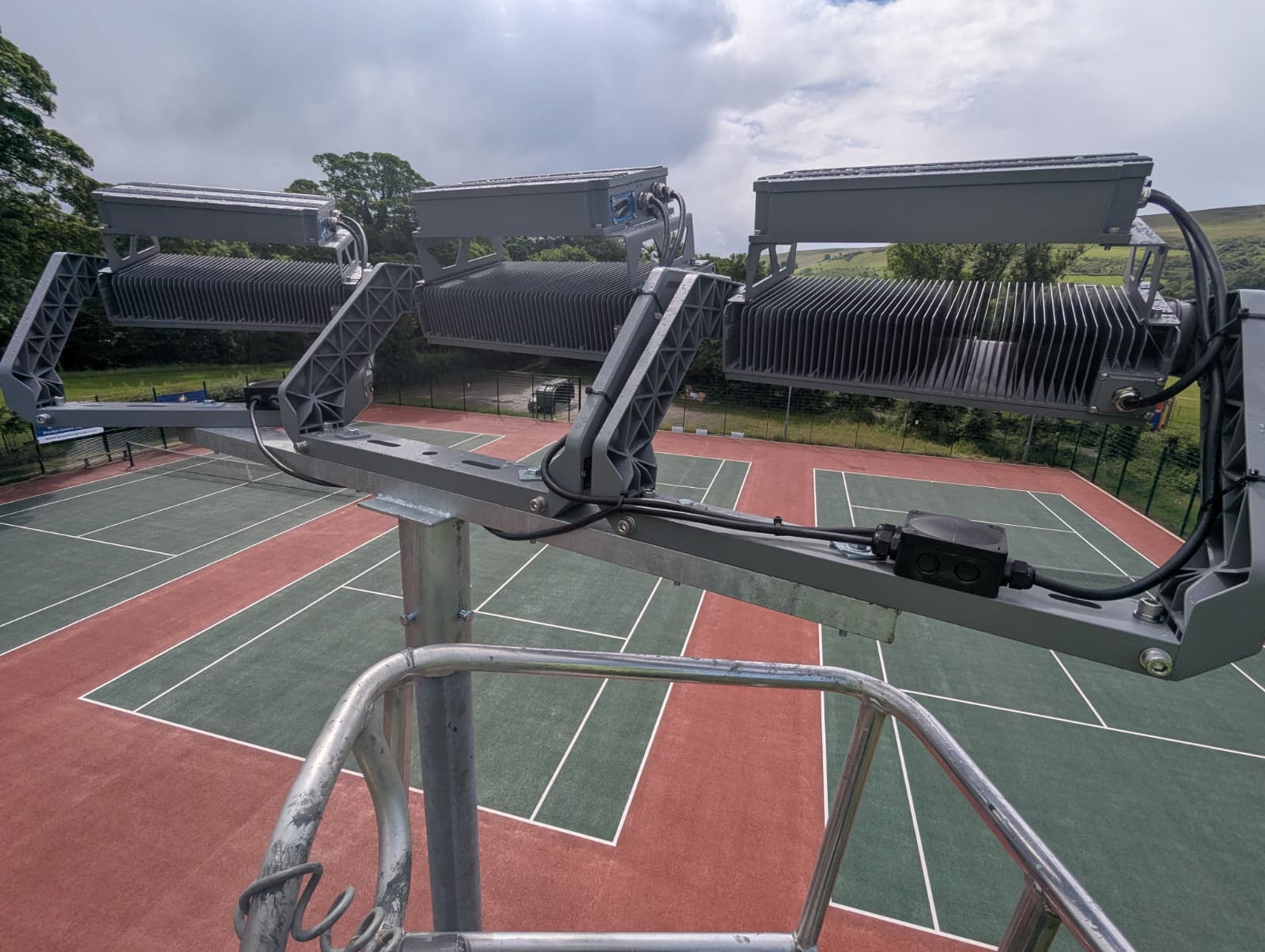 LED floodlight heads mounted on a column at a sports venue.